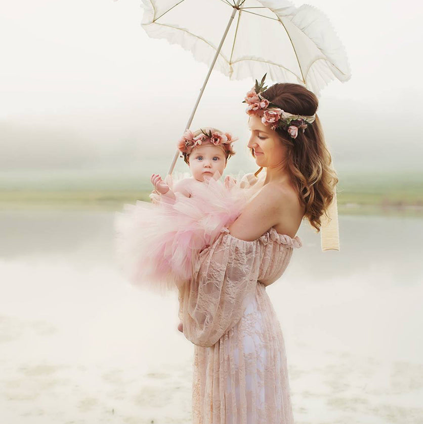 mom holding a baby wearing beautiful flower headpiece handmade by designer Daniela Mallas of Honeydrops Designs